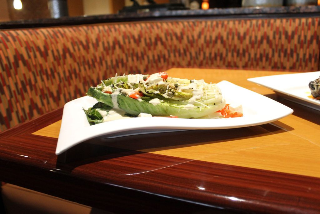 ROMAIN WEDGE SALAD: Romain lettuce with grape tomatoes with signature bleu cheese dressing, twice smoked bacon and croutons.